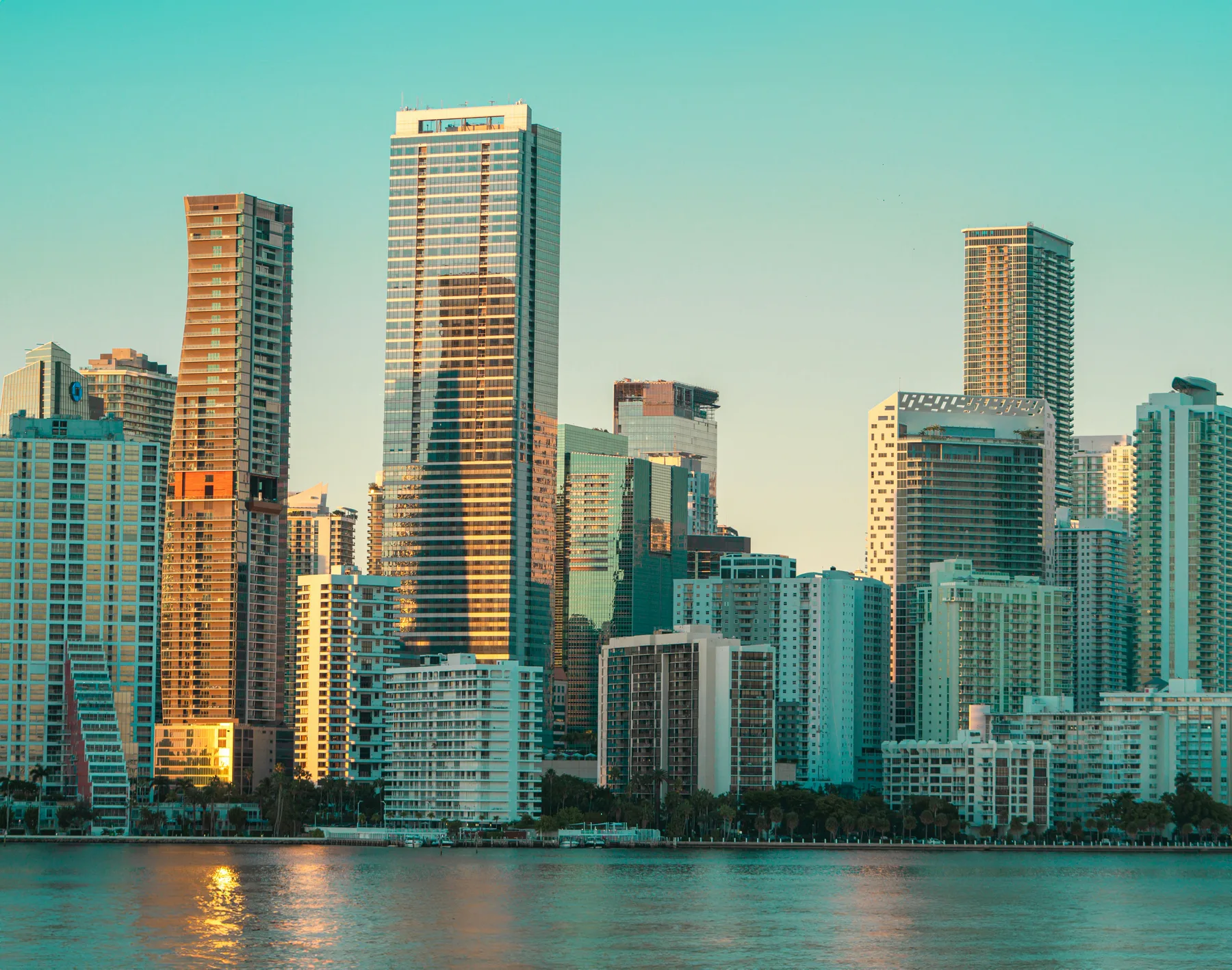 Brickell's towers in golden evening light across Biscayne Bay, Miami